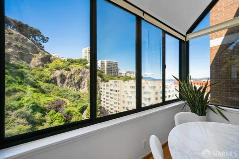 a living room with stainless steel appliances kitchen island granite countertop furniture and a large window