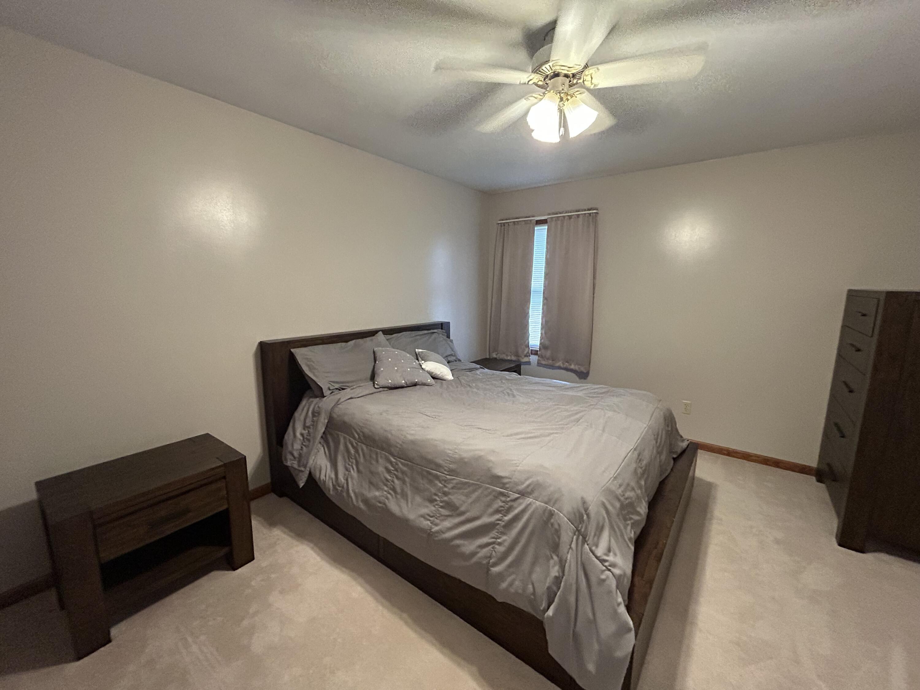 8876 North Lilac Street Demotte, IN 46310 - Photo 13 of 23 a bedroom with a bed and a chandelier