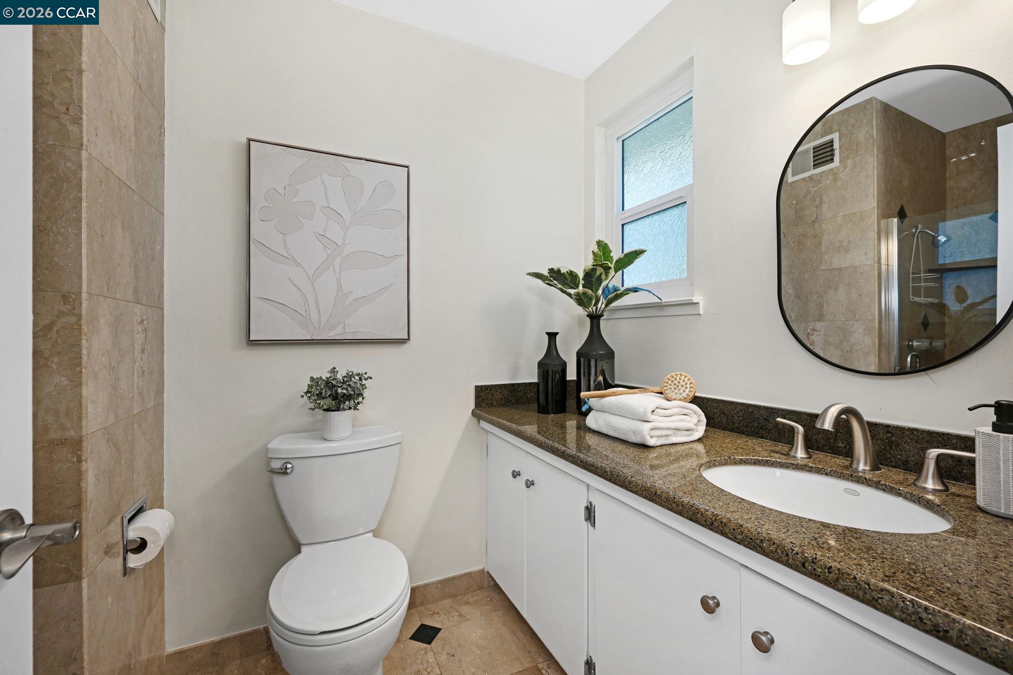 414 Peppertree Road Walnut Creek, CA 94598 - Photo 26 of 49 a bathroom with a granite countertop toilet a sink and a mirror