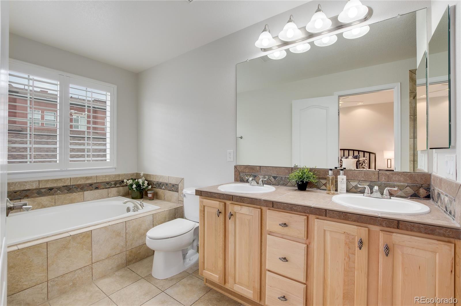 624 Green Ash Street, Unit G Highlands Ranch, CO 80129 - Photo 17 of 40 a bathroom with a granite countertop sink a toilet and bathtub