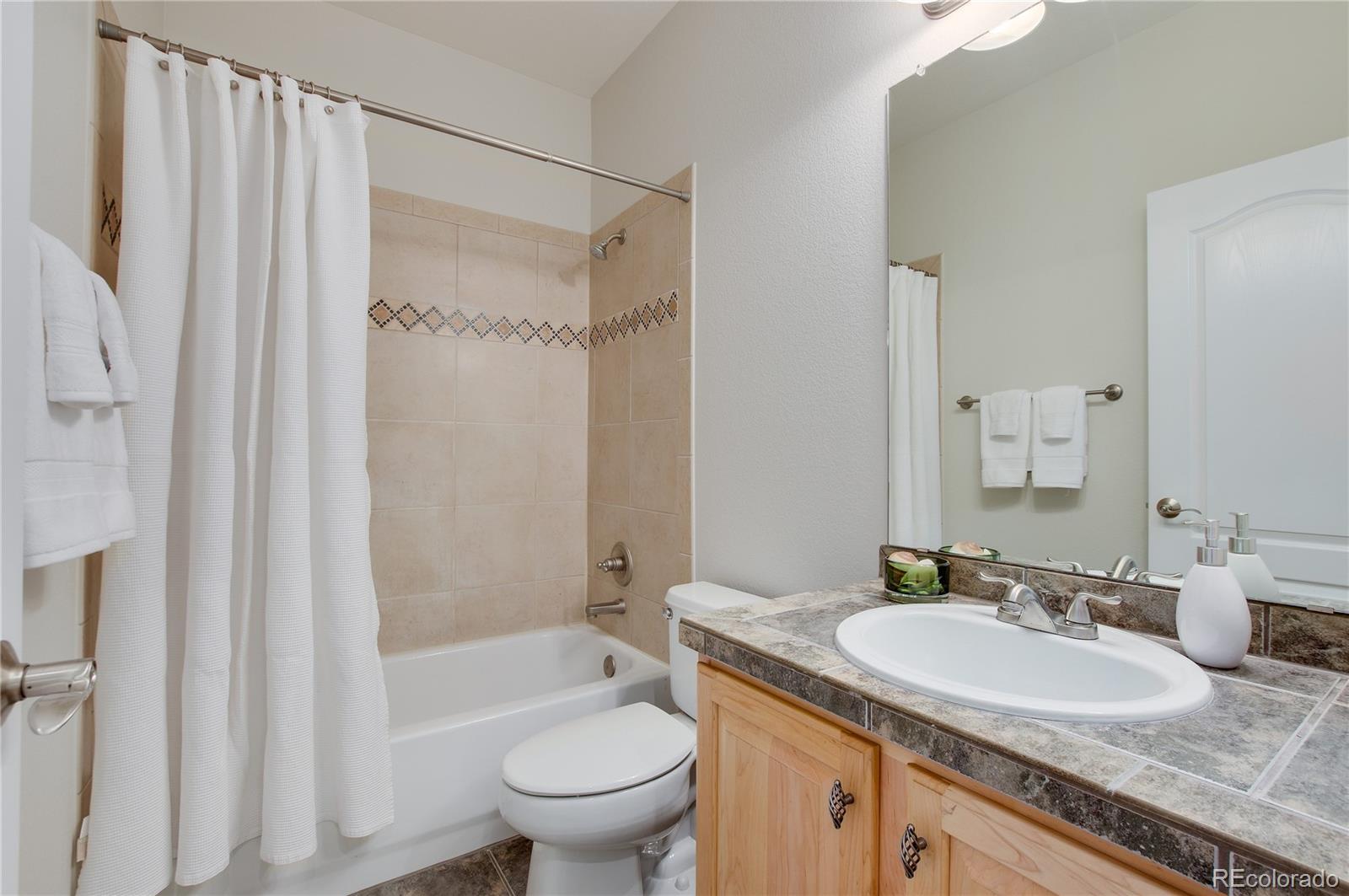 624 Green Ash Street, Unit G Highlands Ranch, CO 80129 - Photo 20 of 40 a bathroom with a granite countertop sink toilet and shower