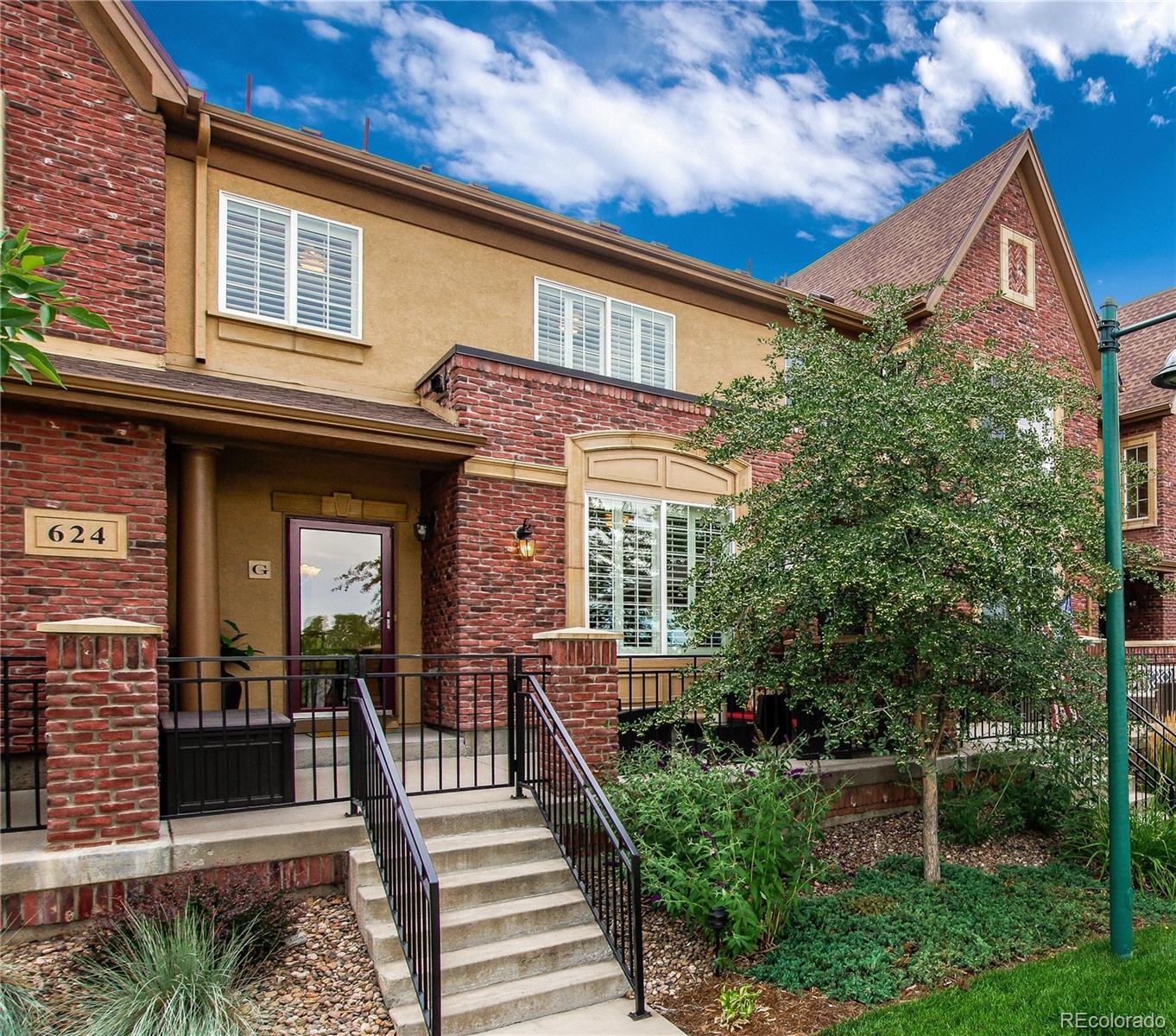 624 Green Ash Street, Unit G Highlands Ranch, CO 80129 - Photo 2 of 40 a view of a house with a small yard plants and large tree