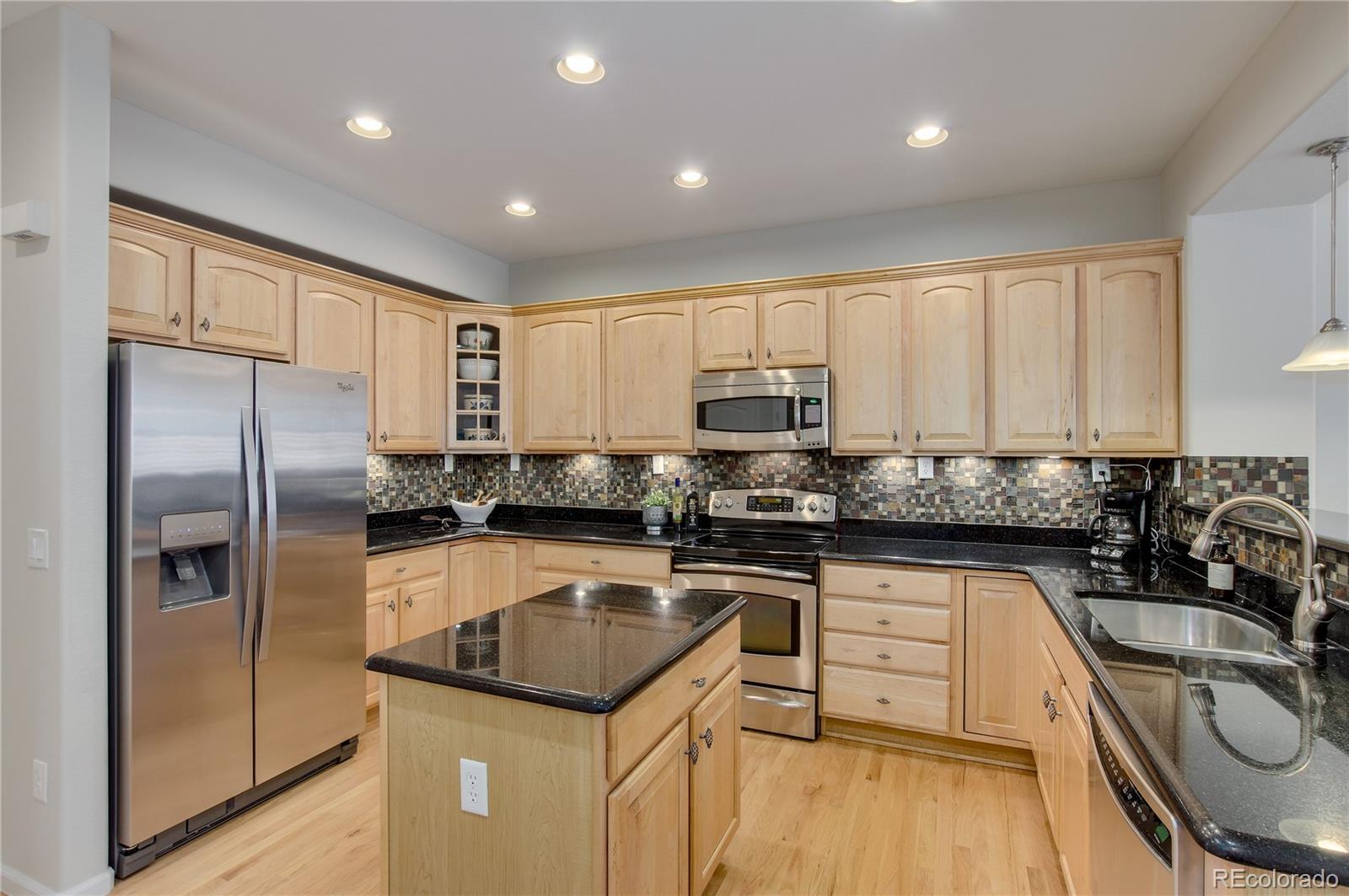 624 Green Ash Street, Unit G Highlands Ranch, CO 80129 - Photo 7 of 40 a kitchen with granite countertop a sink stainless steel appliances and cabinets