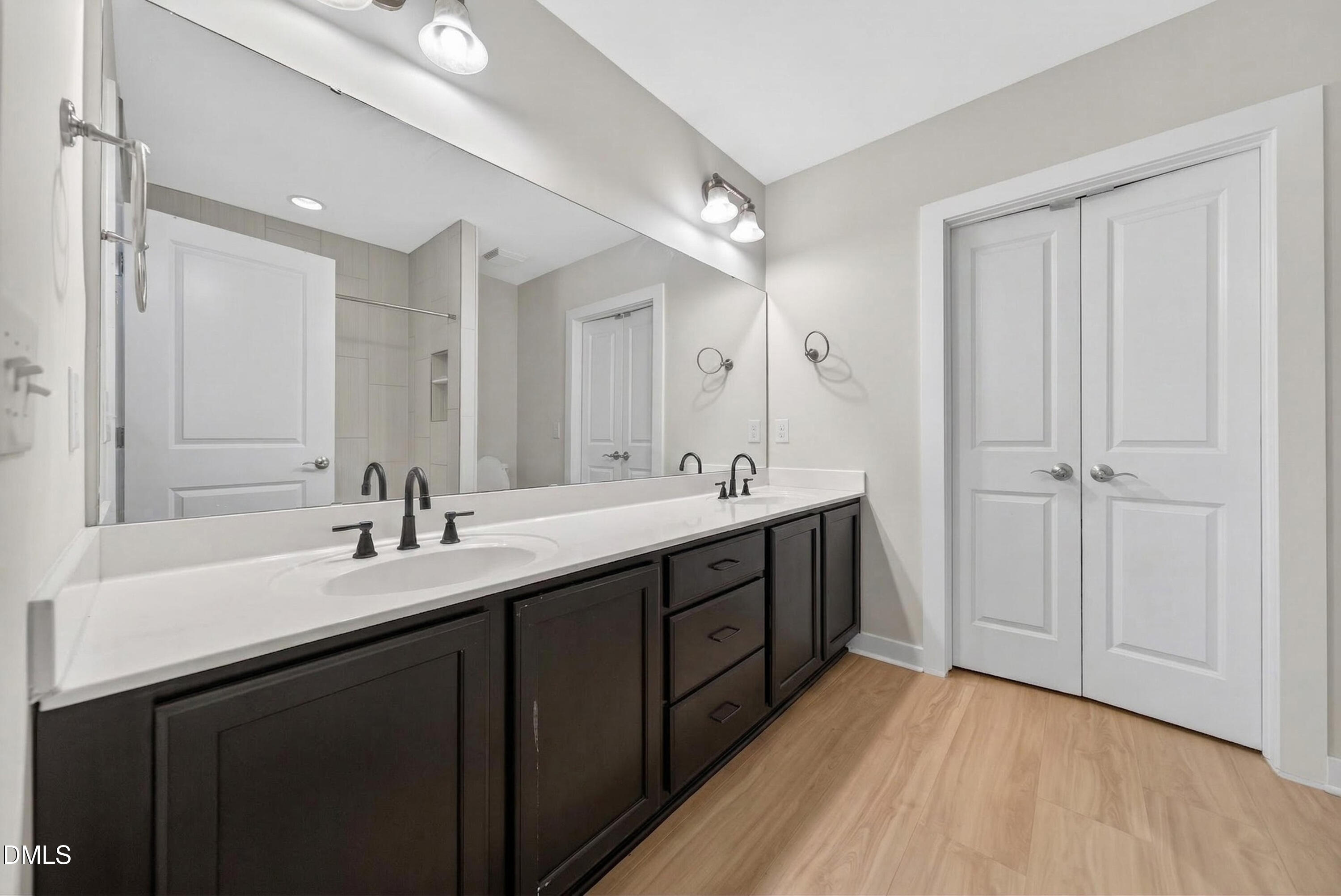 444 South Blount Street, Unit 111 Raleigh, NC 27601 - Photo 15 of 40 a bathroom with a double vanity sink and mirror