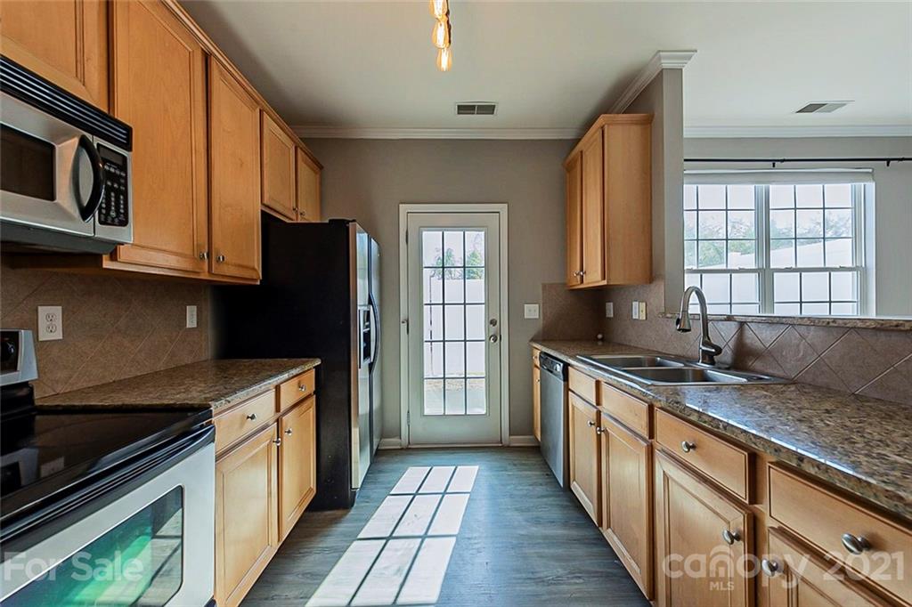 1906 Travertine Lane Fort Mill, SC 29708 - Photo 4 of 17 a kitchen with stainless steel appliances granite countertop a stove a sink and a microwave