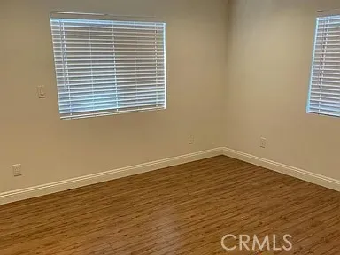 an empty room with wooden floor and cabinet