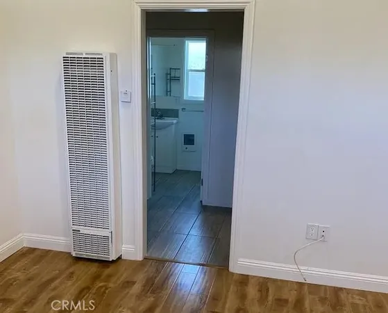 a view of a hallway with wooden floor and closet