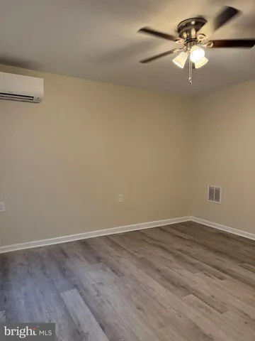 a view of a room with a ceiling fan and wooden floor