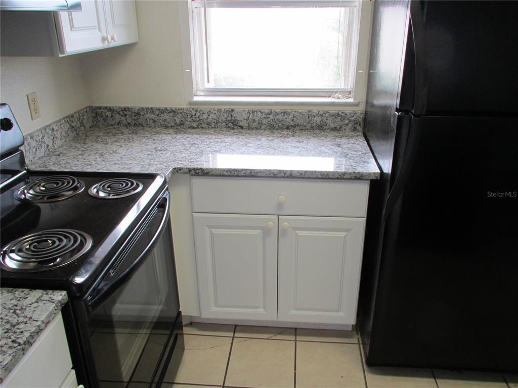 25100 Sandhill Boulevard, Unit 202 Punta Gorda, FL 33983 - Photo 11 of 12 a kitchen with a stove and a microwave