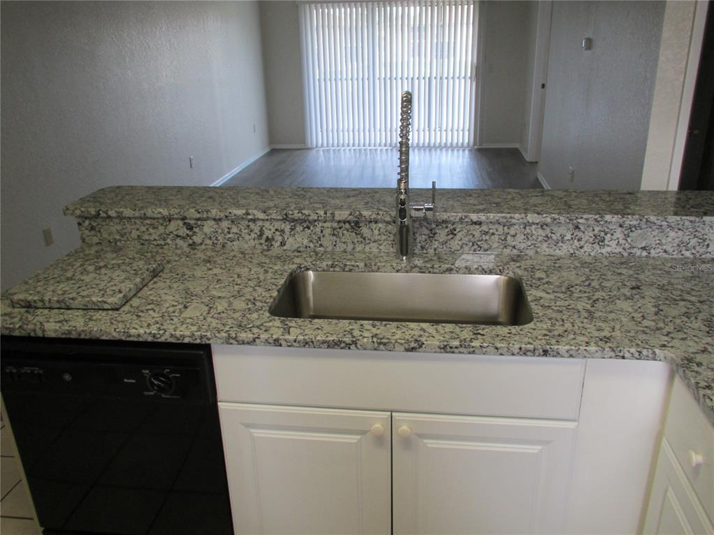 25100 Sandhill Boulevard, Unit 202 Punta Gorda, FL 33983 - Photo 9 of 12 a kitchen with granite countertop a sink and a granite counter tops