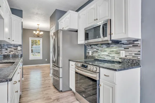 a view of a house with a big yard and large trees