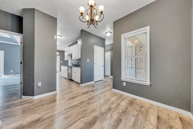 a view of a livingroom with a chandelier fan and a wooden floor