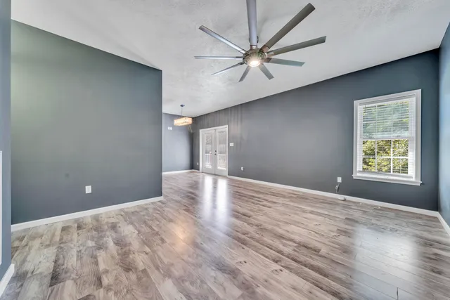 a view of empty room with wooden floor
