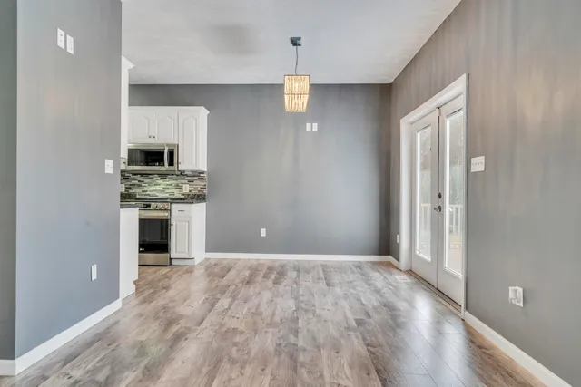 a kitchen with granite countertop white cabinets and white appliances