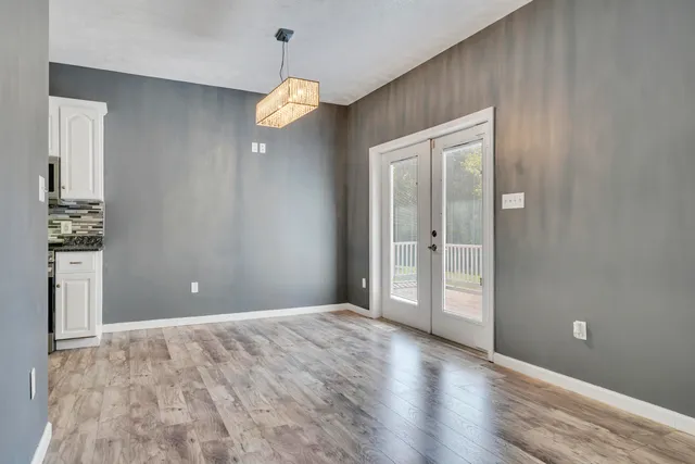 a large white kitchen with granite countertop a lot of counter space and a sink