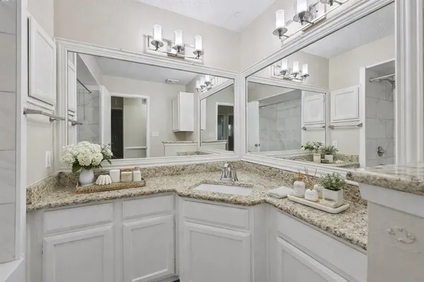a bathroom with a granite countertop sink and a mirror