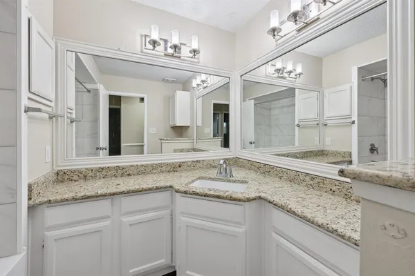 a bathroom with a granite countertop bathtub and a shower
