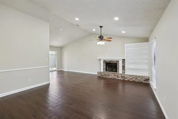 an empty room with wooden floor and fireplace