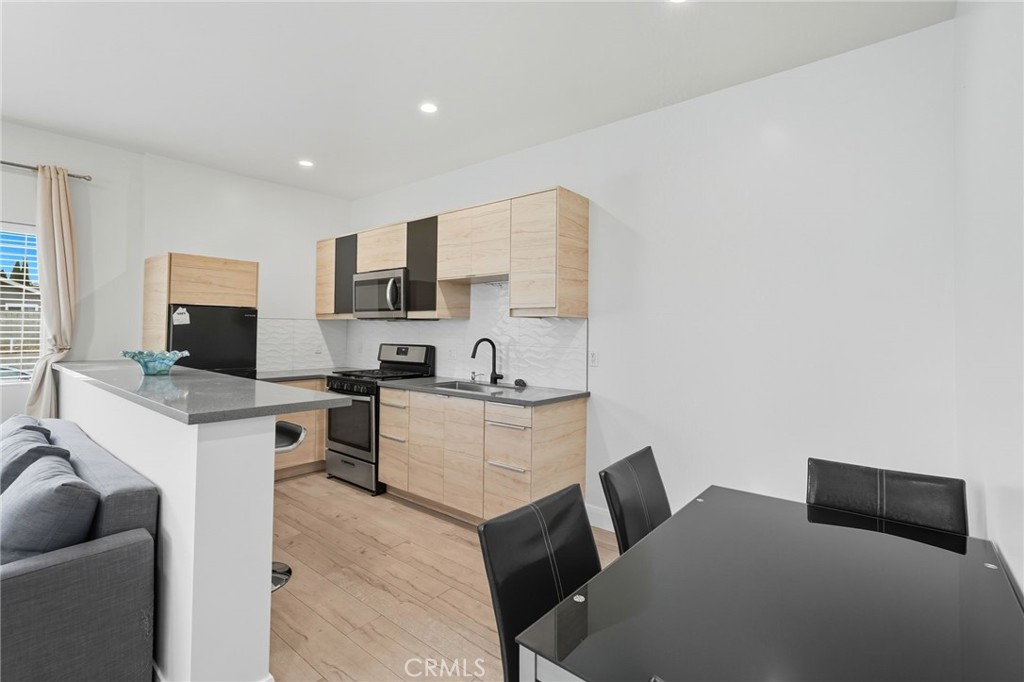 11642 Gothic Avenue Granada Hills, CA 91344 - Photo 12 of 27 a kitchen with a sink cabinets and a couch