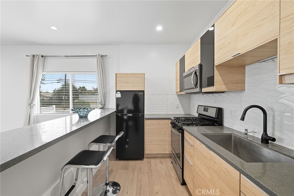 11642 Gothic Avenue Granada Hills, CA 91344 - Photo 14 of 27 a kitchen with a sink a counter top space and stainless steel appliances