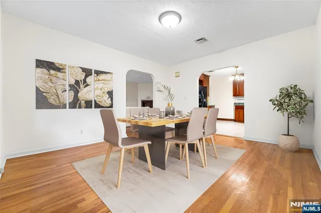 a dining room with furniture potted plants and wooden floor