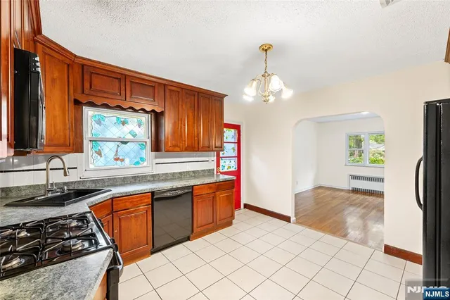a kitchen with stainless steel appliances a sink stove and cabinets