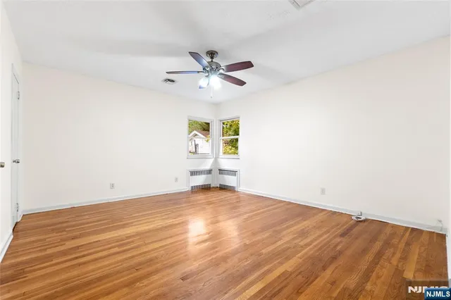 an empty room with windows and fan