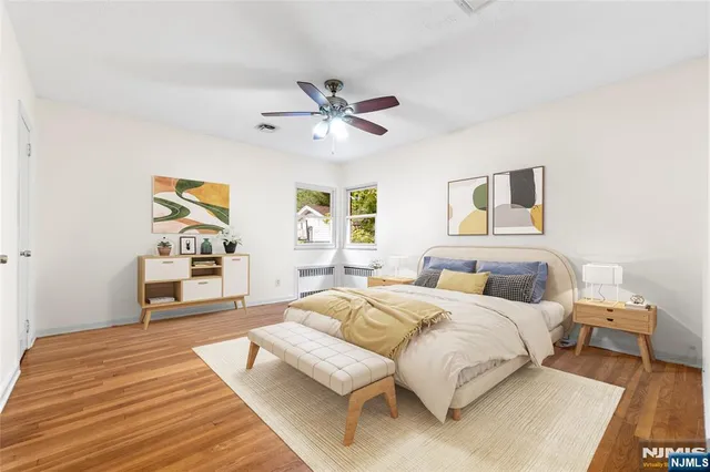 a bedroom with a bed wooden floor and window