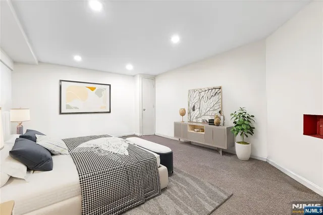 a bedroom with a large bed and a potted plant