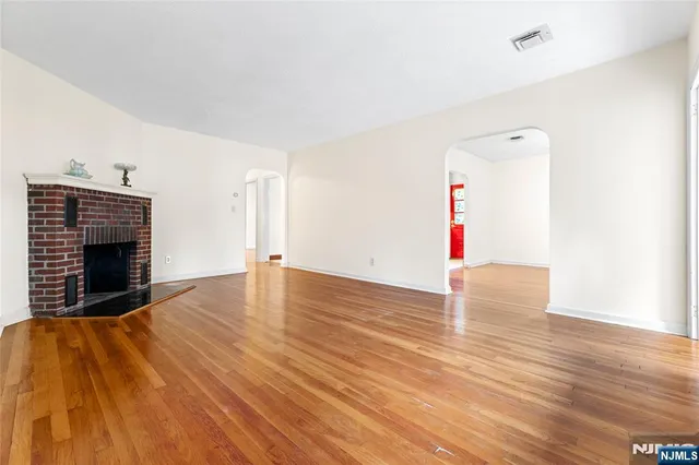 a view of empty room with wooden floor and fireplace