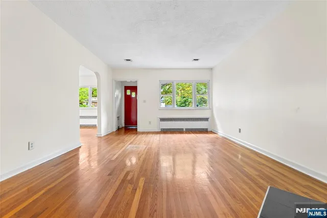 an empty room with window and wooden floor