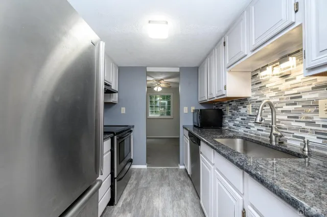 a kitchen with granite countertop a sink and a stove