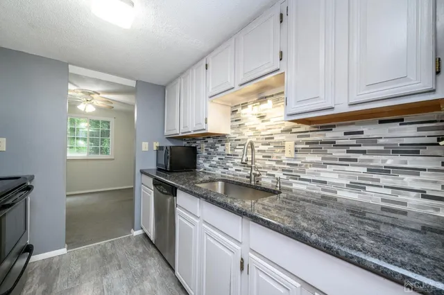 a kitchen with granite countertop wooden cabinets and stainless steel appliances