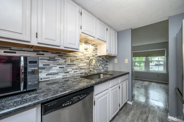 a view of staircase with railing and white walls