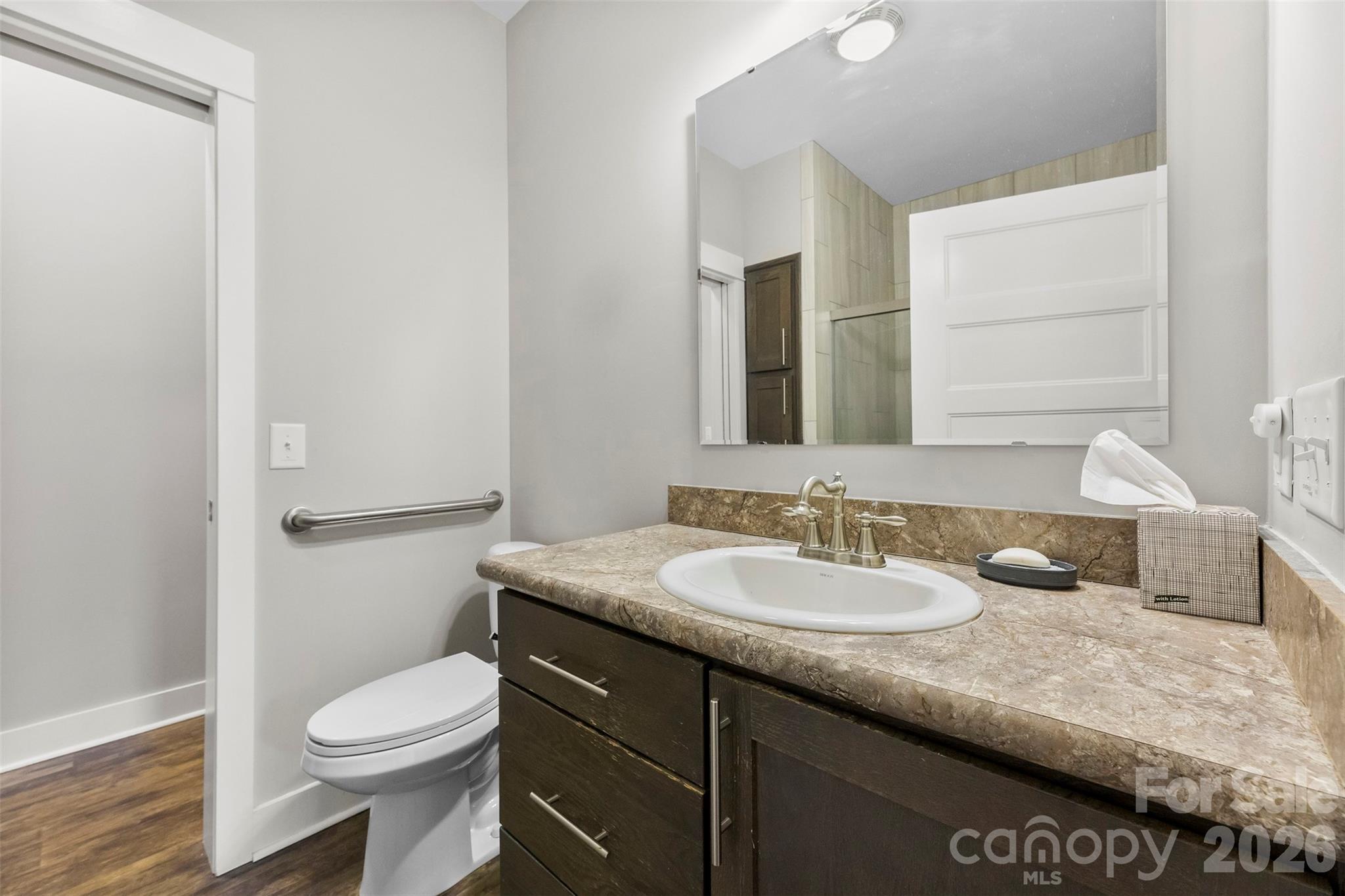 4242 John Ritchie Road Iron Station, NC 28080 - Photo 38 of 46 a bathroom with a granite countertop sink a toilet and a mirror