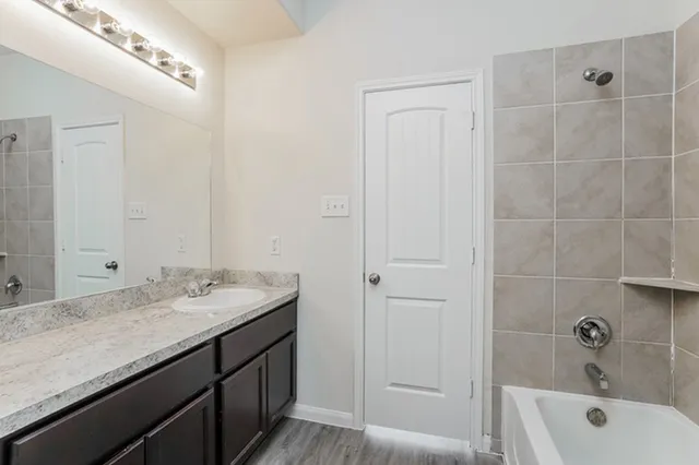 a bathroom with a granite countertop sink a toilet and shower