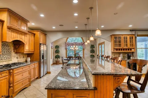 a dining room with furniture a chandelier and a large window
