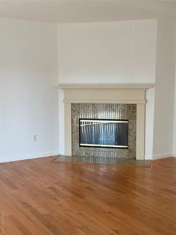a view of a room with wooden floor and fireplace