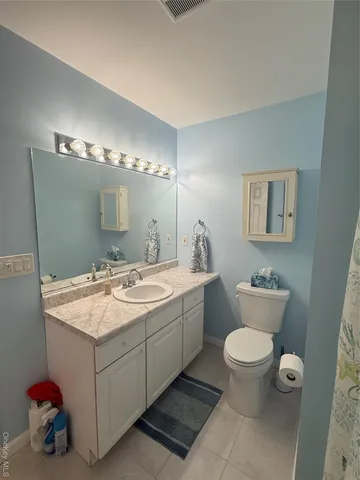 a bathroom with a granite countertop sink a toilet and a mirror