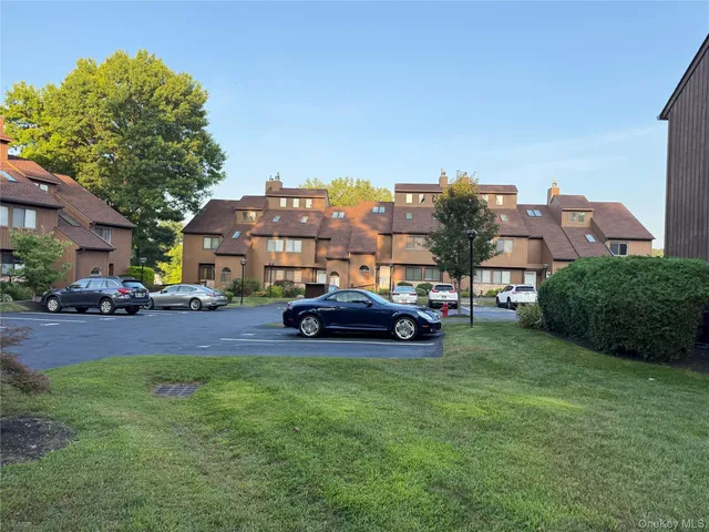 a car parked in front of a house next to a yard
