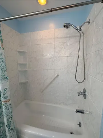 a bathroom with a bath tub with a shower