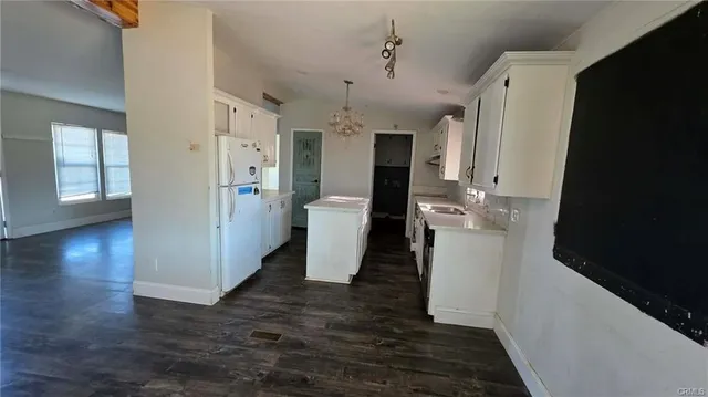 a view of a hallway with wooden floor and entryway