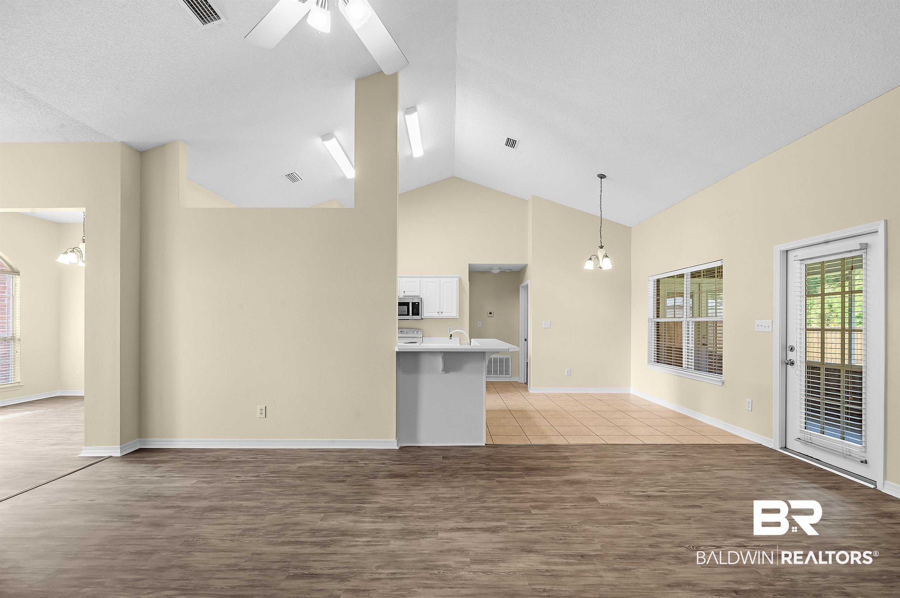 12443 Venice Boulevard Foley, AL 36535 - Photo 24 of 59 Interior space with high vaulted ceiling, ceiling fan with notable chandelier, a textured ceiling, decorative light fixtures, and light hardwood / wood-style floors
