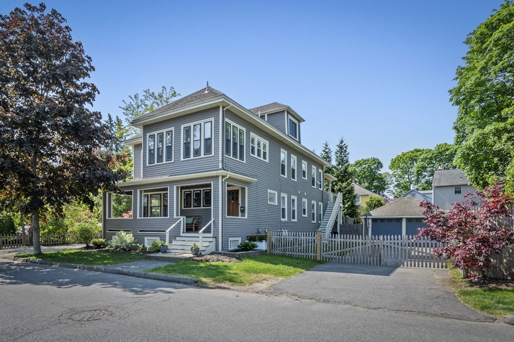 a front view of a house with a garden and trees