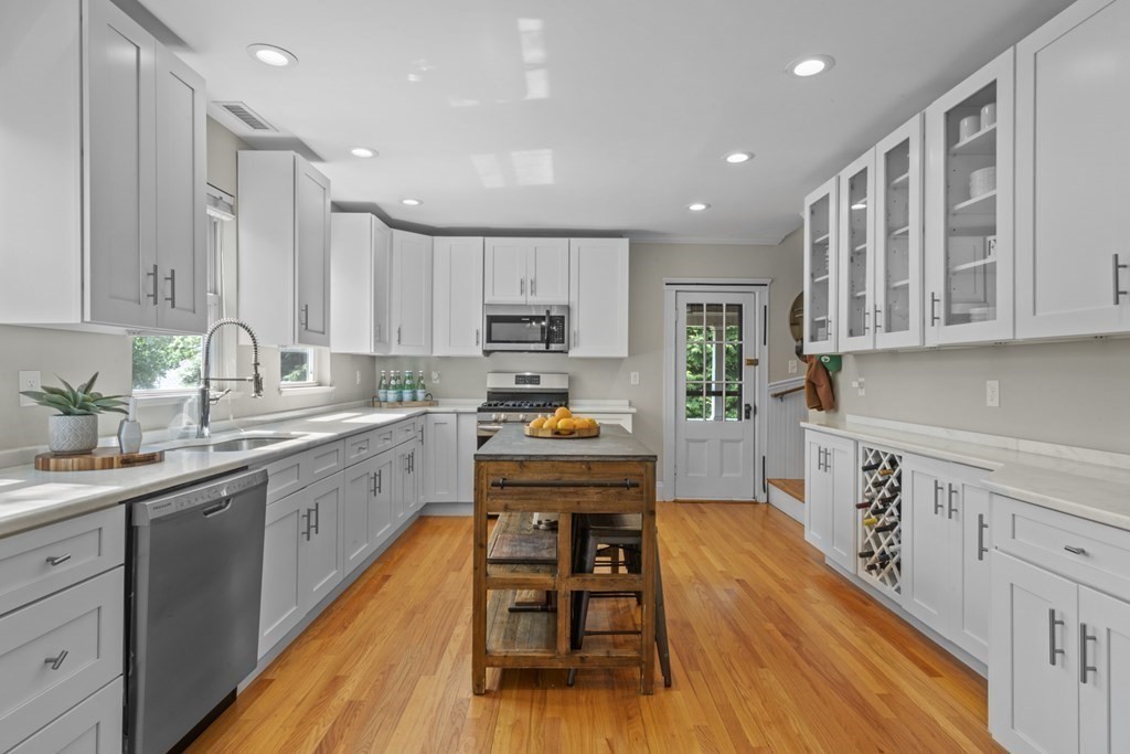 26 Cedar Street, Unit 2 Marblehead, MA 01945 - Photo 15 of 37 a kitchen with kitchen island granite countertop wooden floors wooden cabinets and appliances