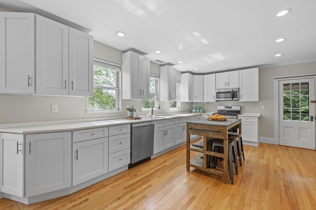 26 Cedar Street, Unit 2 Marblehead, MA 01945 - Photo 16 of 37 a kitchen with wooden floors and white cabinets