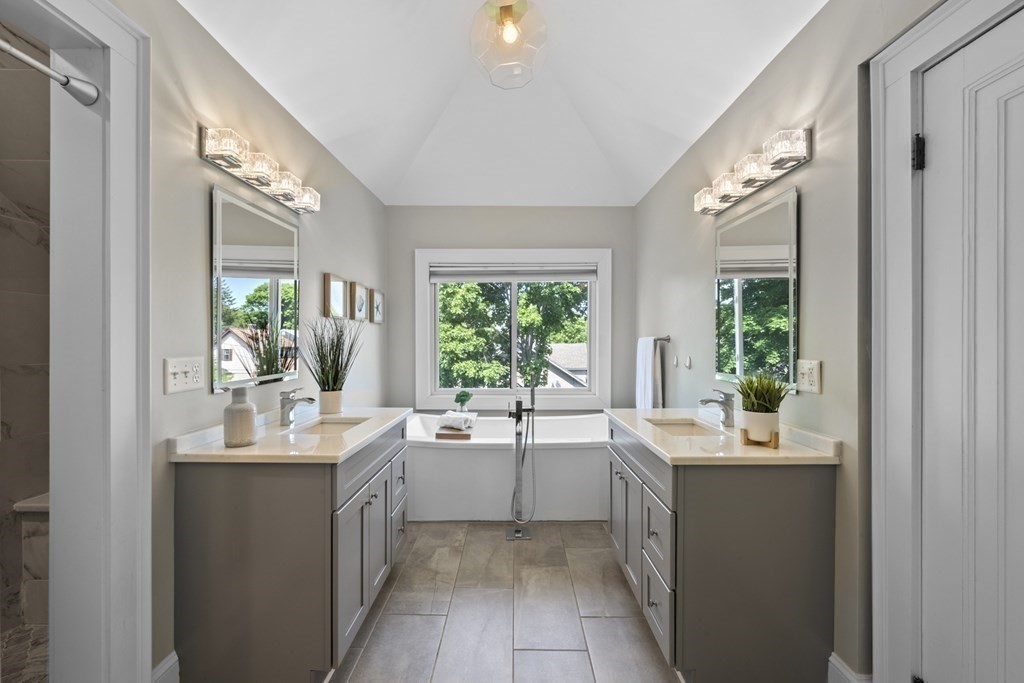 26 Cedar Street, Unit 2 Marblehead, MA 01945 - Photo 30 of 37 a bathroom with a double vanity sink a large mirror a bathtub and window