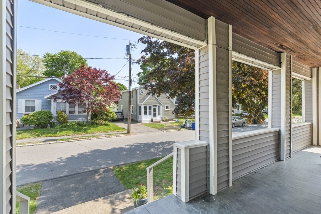 26 Cedar Street, Unit 2 Marblehead, MA 01945 - Photo 5 of 37 a view of a house with a porch and a floor to ceiling window and potted plants
