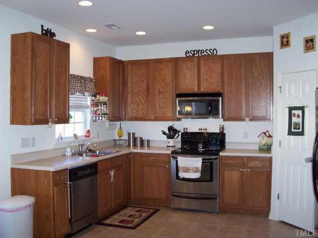 164 Trevor Ridge Drive Holly Springs, NC 27540 - Photo 5 of 12 a kitchen with stainless steel appliances a stove a sink and a microwave