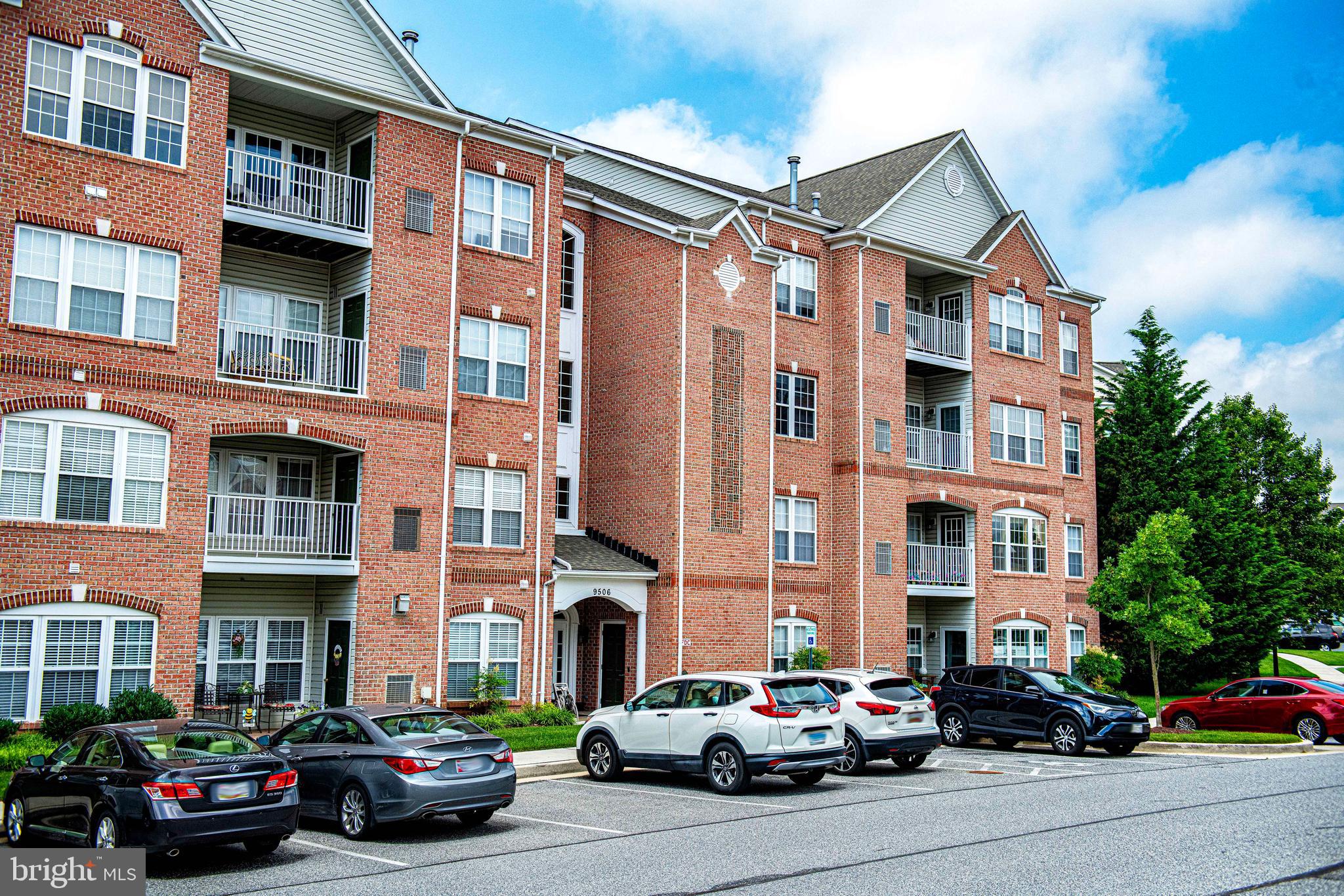 9506 Amberleigh Lane, Unit 9506A Perry Hall, MD 21128 - Photo 3 of 33 a city street lined with cars parked in front of a building